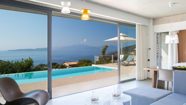 Una sala de estar moderna con vista a la piscina, una mesa de vidrio y un área de estar cómoda.