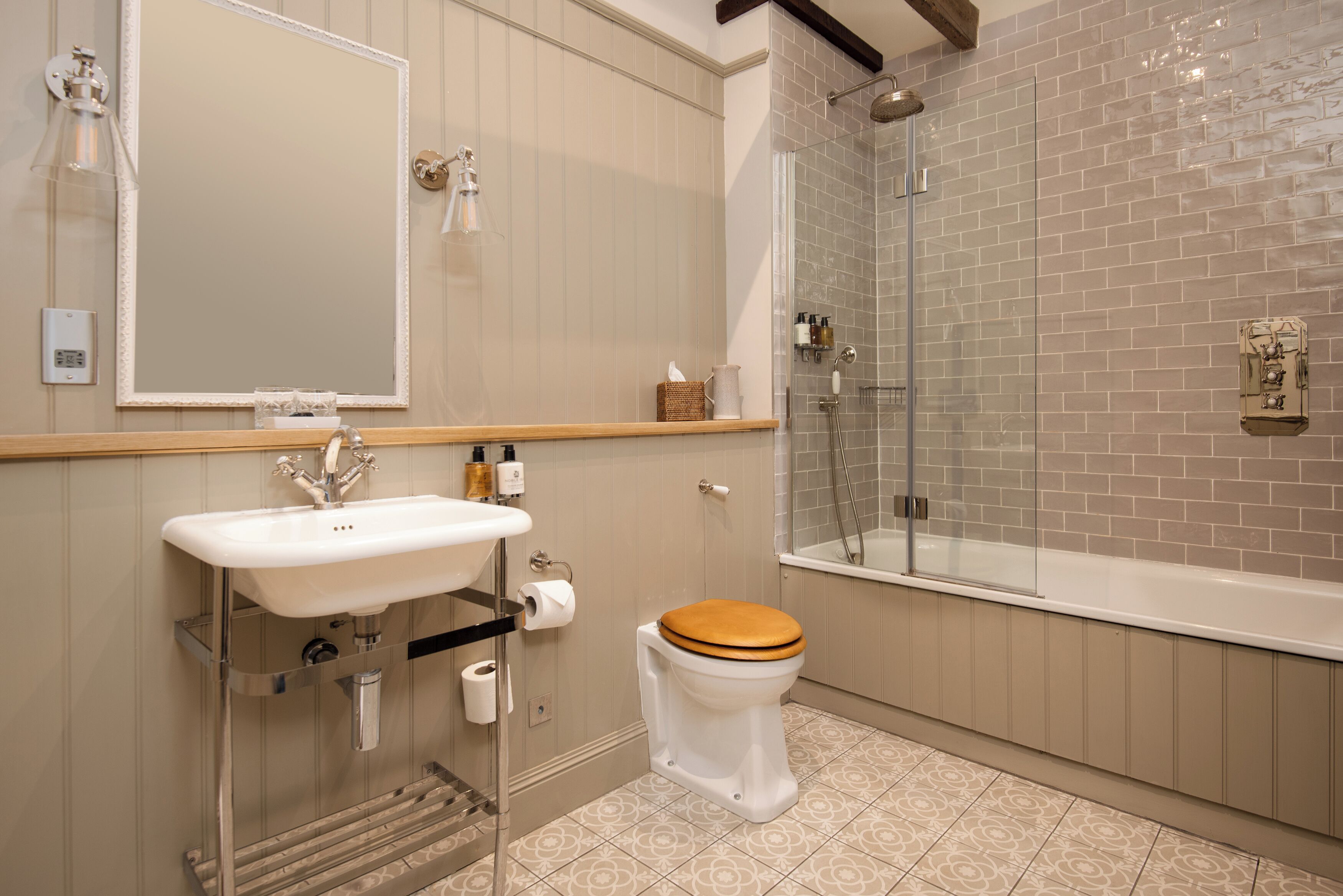 A bathroom with a sink, mirror, toilet, and shower.