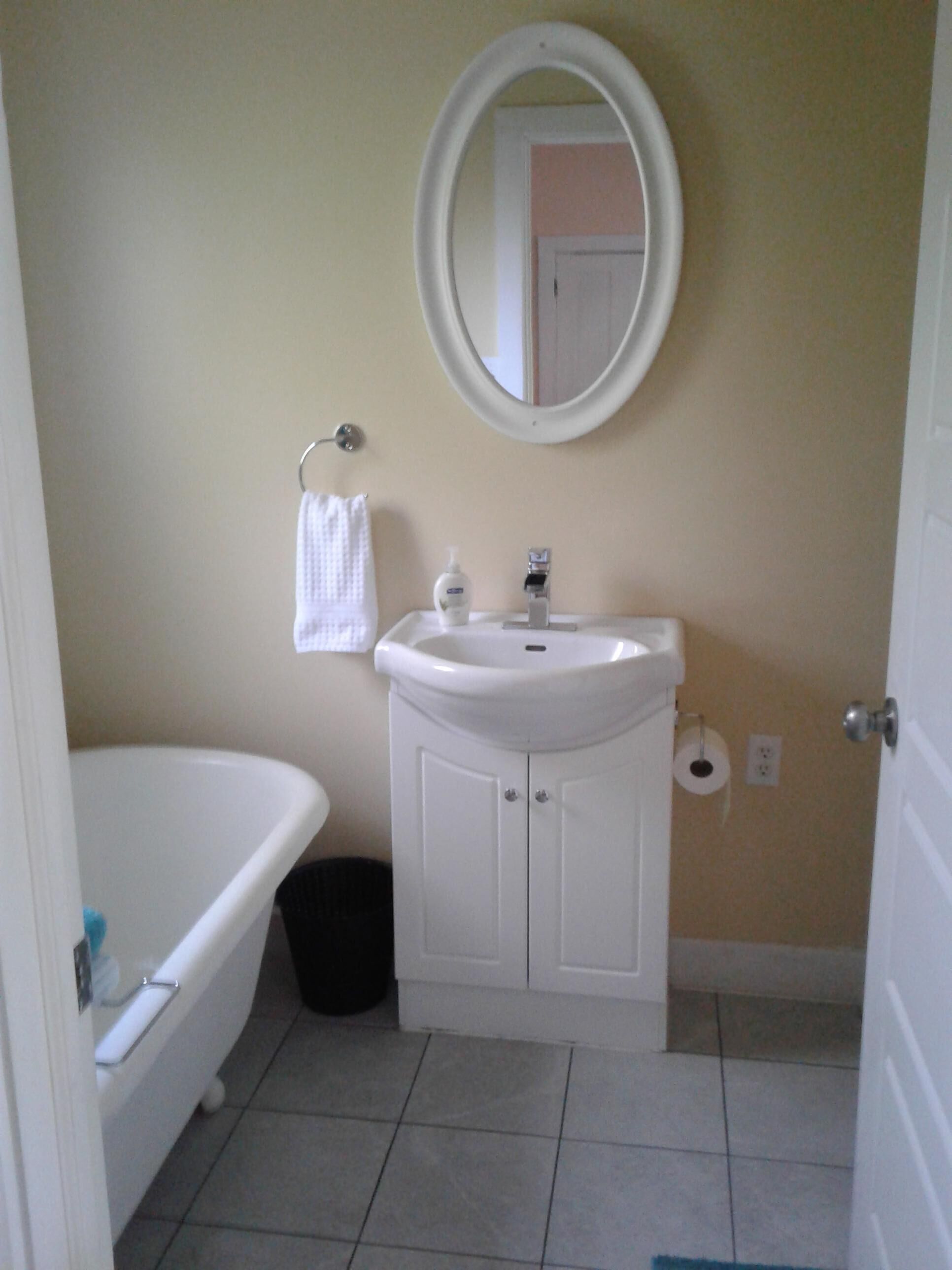 A bathroom with a white sink, a mirror, a towel, and a toilet.