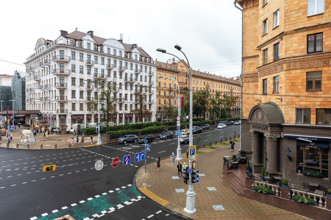 A street view with a Grand Cafe building, a roundabout, and classic architecture.