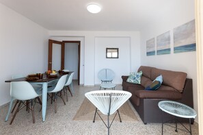 Een knus woongedeelte met een eethoek, een bank en een kleine tafel.