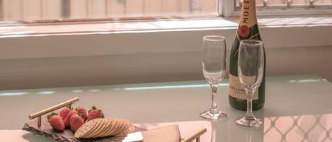 Una mesa con una botella de champán Moët & Chandon, dos copas, fresas, galletas y un cuchillo.