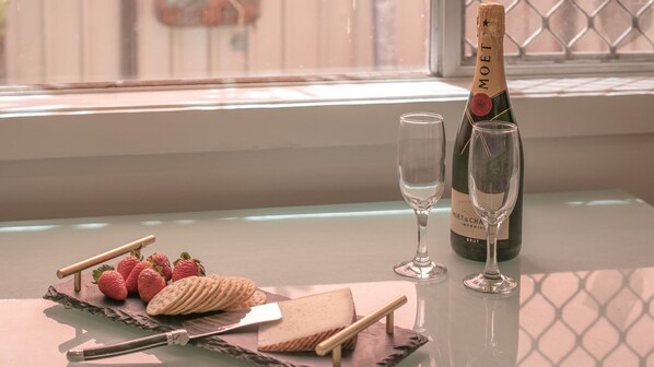 A table with a bottle of Moët & Chandon champagne, two glasses, strawberries, biscuits, and a knife. - Yamba Daze Sunset - Walk to the pet-friendly beach from your pet-friendly stay (Yamba)