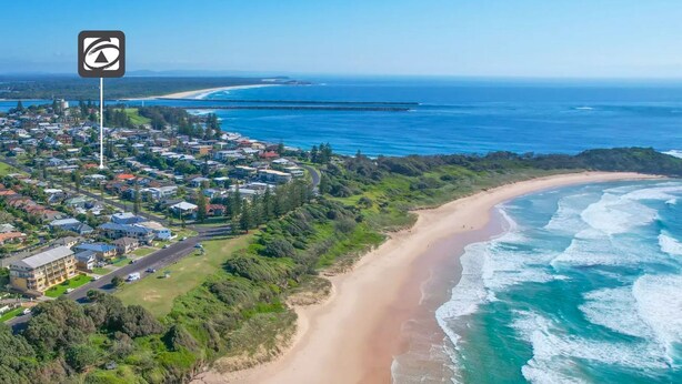 An aerial view of a coastal town with a beachfront, residential area, and a clear view of the ocean. - Yamba Daze Sunset - Walk to the pet-friendly beach from your pet-friendly stay (Yamba)