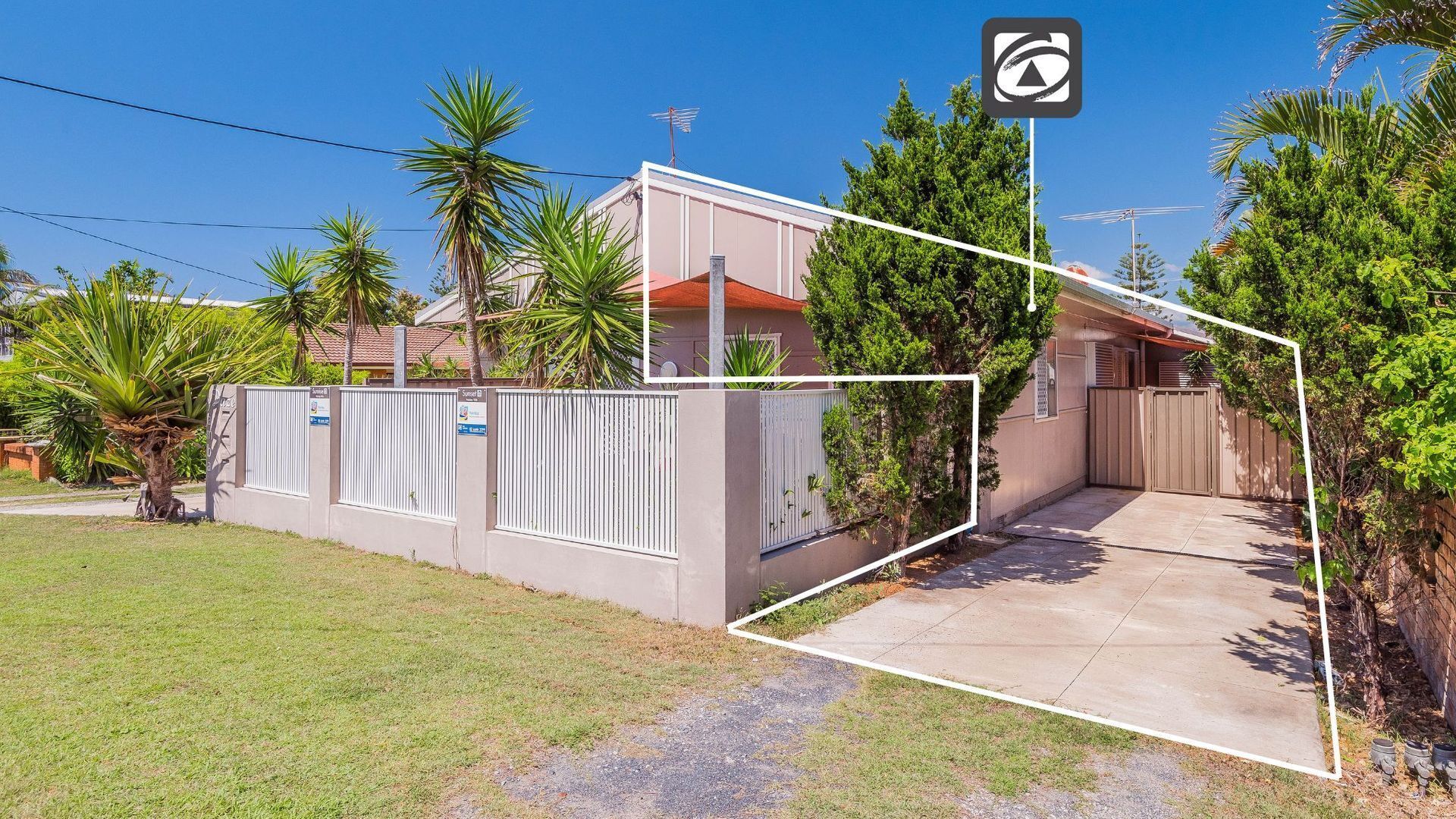 A residential property with a gated entrance, a concrete driveway, and a well-maintained lawn.