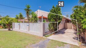 A residential property with a gated entrance, a concrete driveway, and a well-maintained lawn. - Yamba Daze Sunset - Walk to the pet-friendly beach from your pet-friendly stay (Yamba)