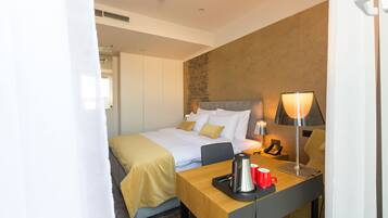 Une chambre d’hôtel avec un lit, une table de chevet avec une lampe, un téléphone et une tasse rouge.