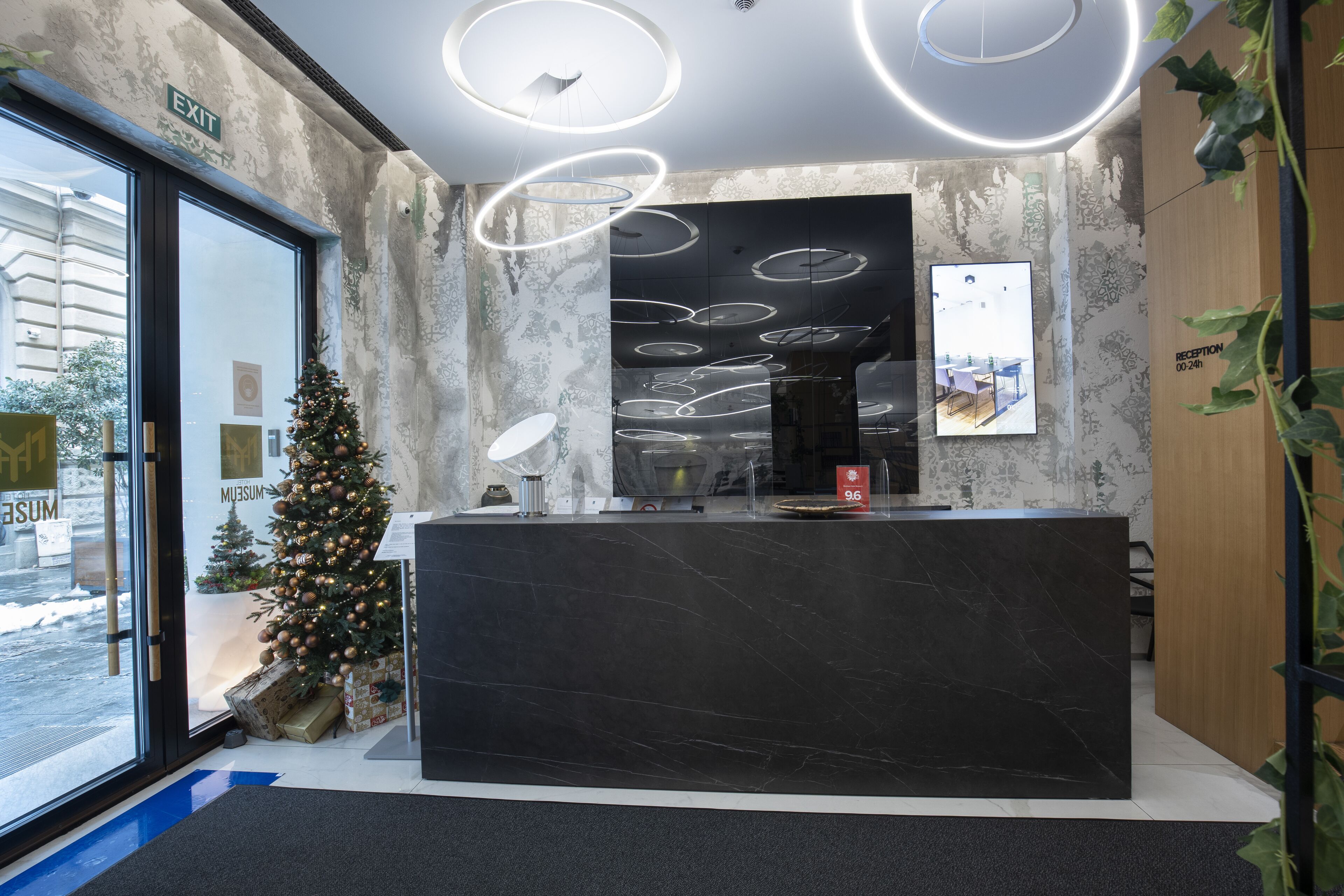 A reception desk with a modern design, a Christmas tree, and a reception sign.