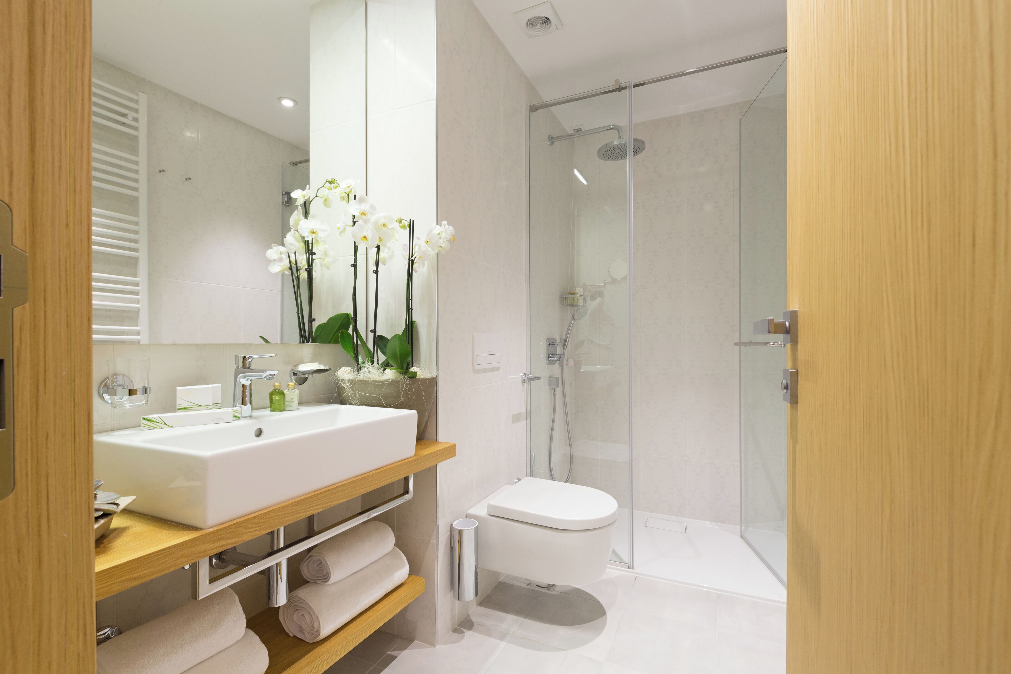 Une salle de bain moderne avec un grand lavabo blanc, des toilettes et une douche à parois de verre.