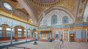 Un interior ornamentado con techo alto, decoraciones intrincadas en paredes y techo, y una zona de estar central.