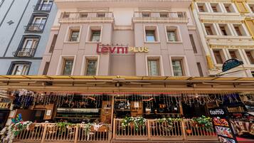Un hotel llamado "Levi Plus" con un balcón decorado con plantas y flores.