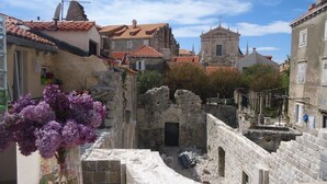 Un pueblo hist órico con muros de piedra, una iglesia y edificios tradicionales con tejados de tejas rojas.