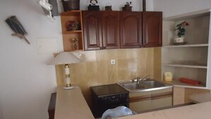 Una cocina con armarios de madera, una estufa, un fregadero y una encimera.