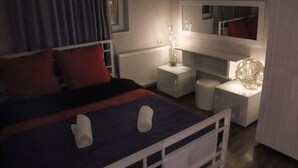 A bedroom with a bed, bedside tables, a mirror, and a lamp. - Apartment on Aghmashenebeli Ave. (Tbilisi)