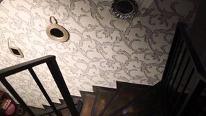 A staircase with a patterned wallpaper and a wooden railing. - Apartment on Aghmashenebeli Ave. (Tbilisi)