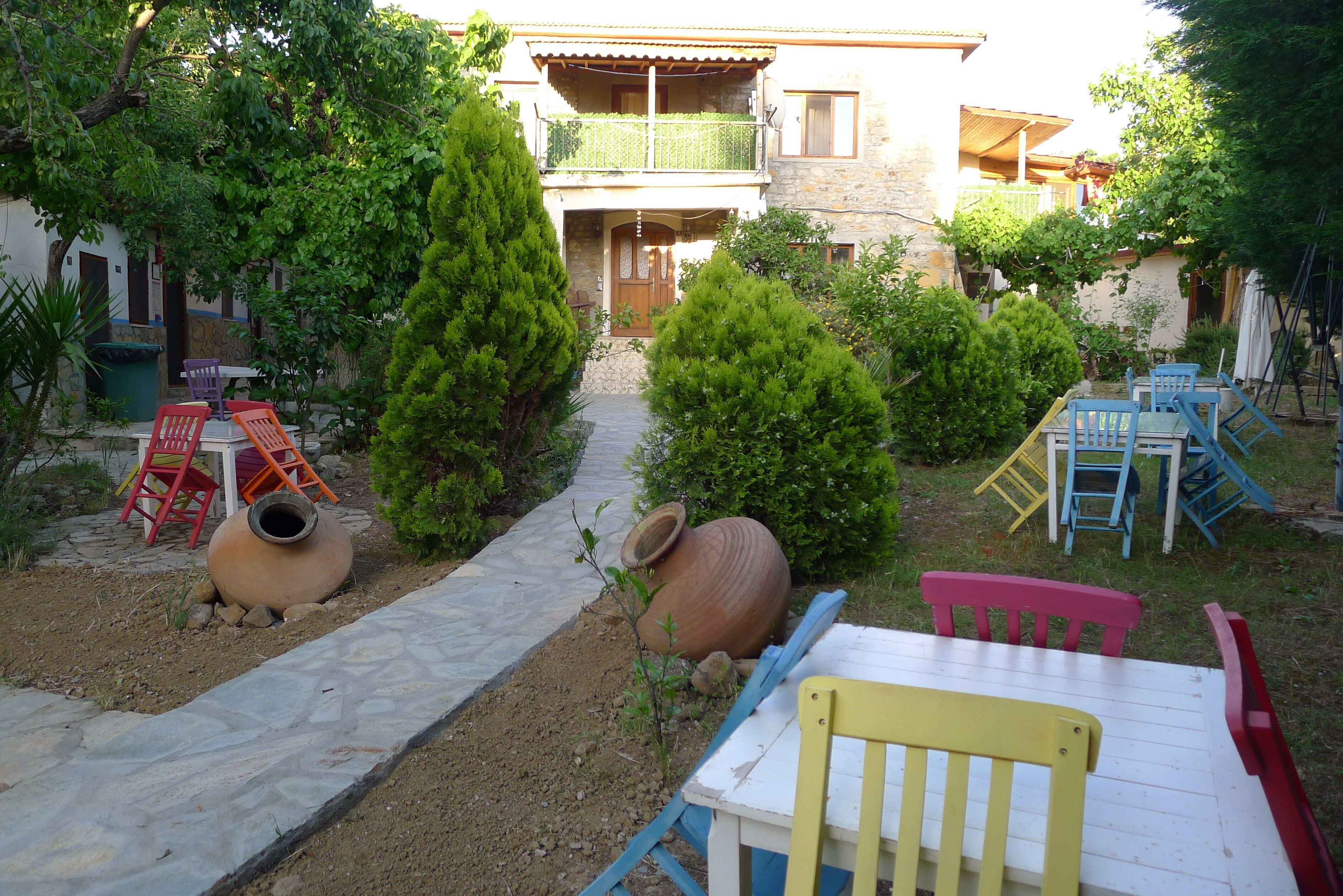 Un patio con un sendero de piedra, mobiliario exterior y un edificio con balcón.