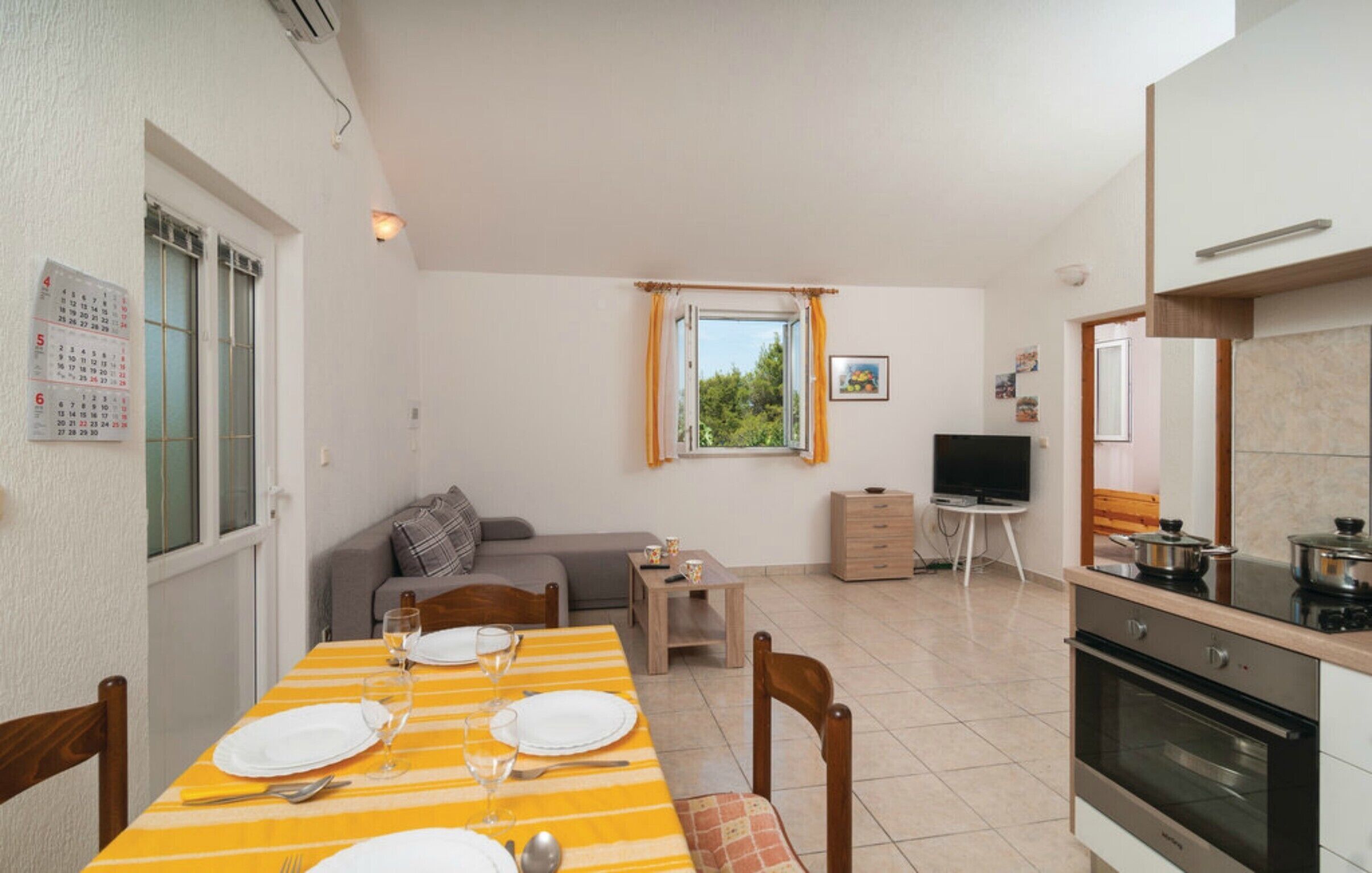 A compact living space with a dining area, kitchenette, and a sofa.