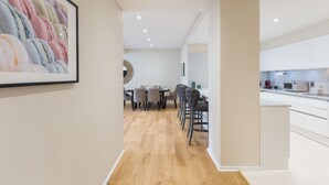 A modern kitchen with white cabinets, a microwave, and a coffee machine. - Urban Chic - Exeter (London)
