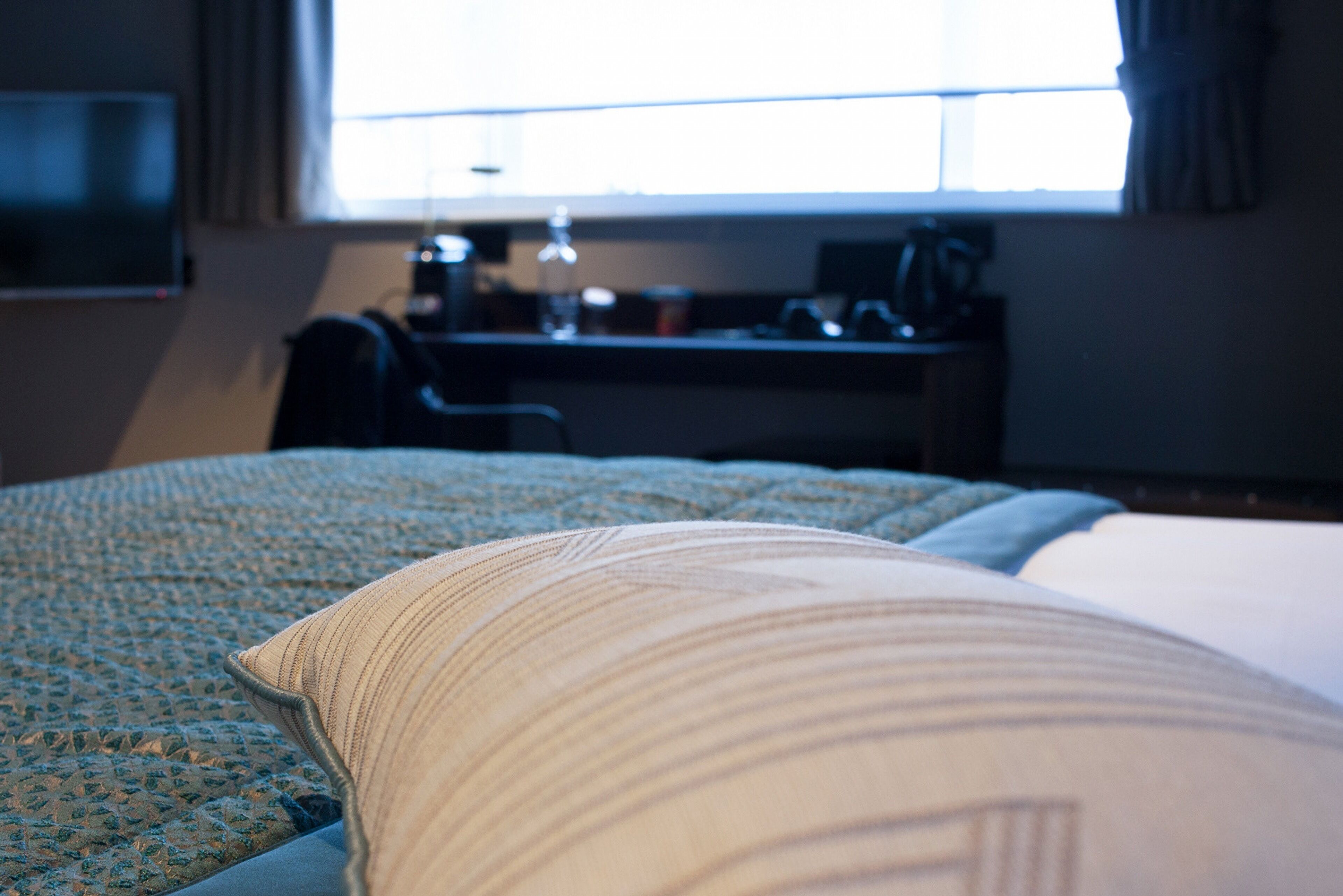 Una habitación de hotel con cama, escritorio y televisión.