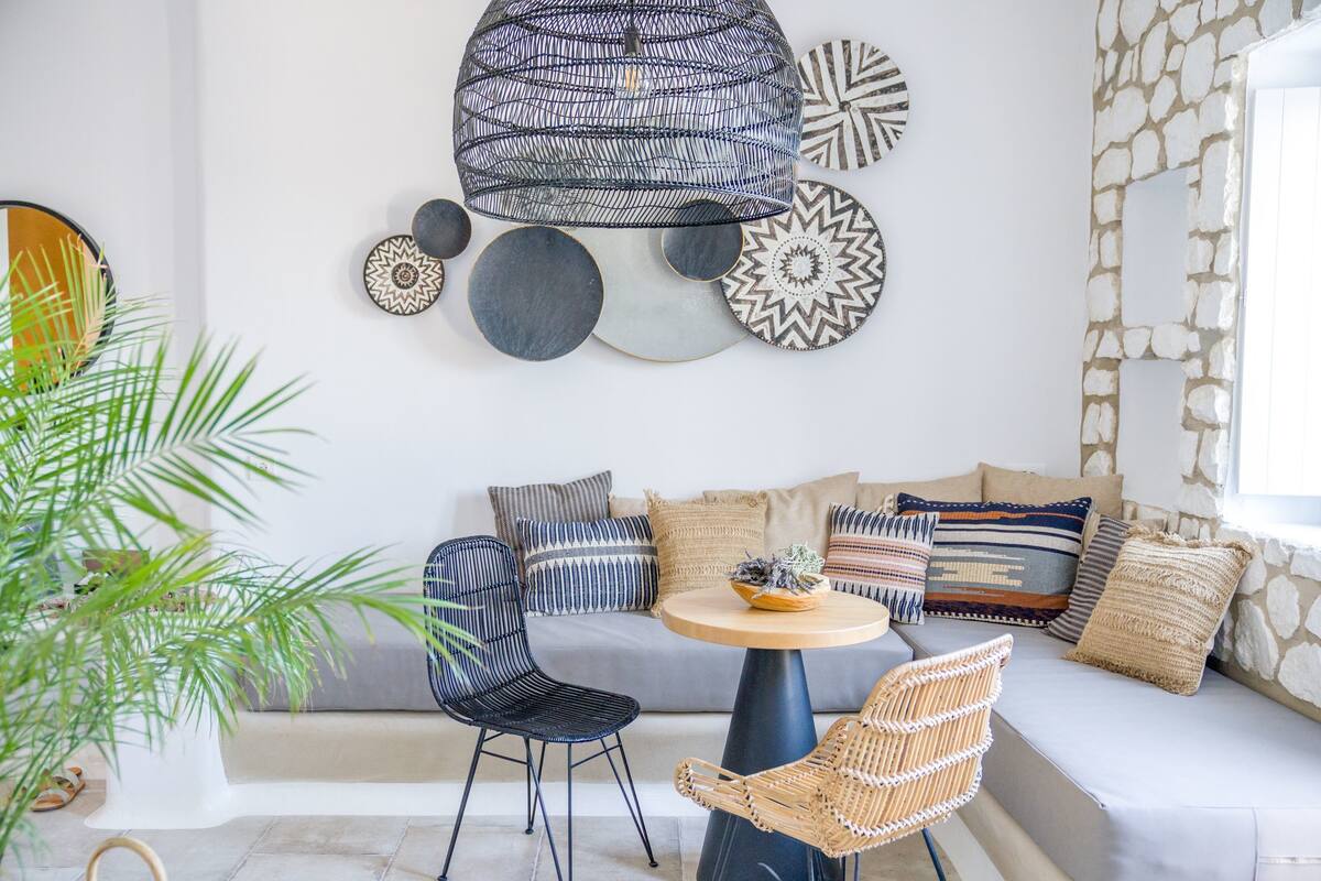 A modern living room with a sofa, two chairs, a round table, and decorative wall art.