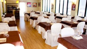 A restaurant with multiple tables set for dining, each with white chairs and brown tablecloths. - Hotel Marinella (Celle Ligure)