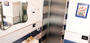 Un baño con espejo, secador de pelo y lavamanos.