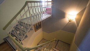 A staircase with ornate metal railings and a wall-mounted light fixture. - Hotel Marinella (Celle Ligure)