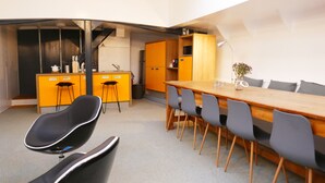 Una cocina moderna con armarios amarillos, una mesa de comedor de madera y sillas negras.