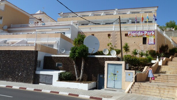 Un bâtiment sur lequel on peut voir une enseigne indiquant « Florida-Park Club », un escalier menant à un balcon et des antennes paraboliques sur le toit.