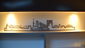 Een muur met een silhouet van een stadshemel en het woord "ROTTERDAM" in het midden.