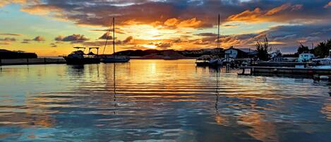 A marina with boats docked at sunset.