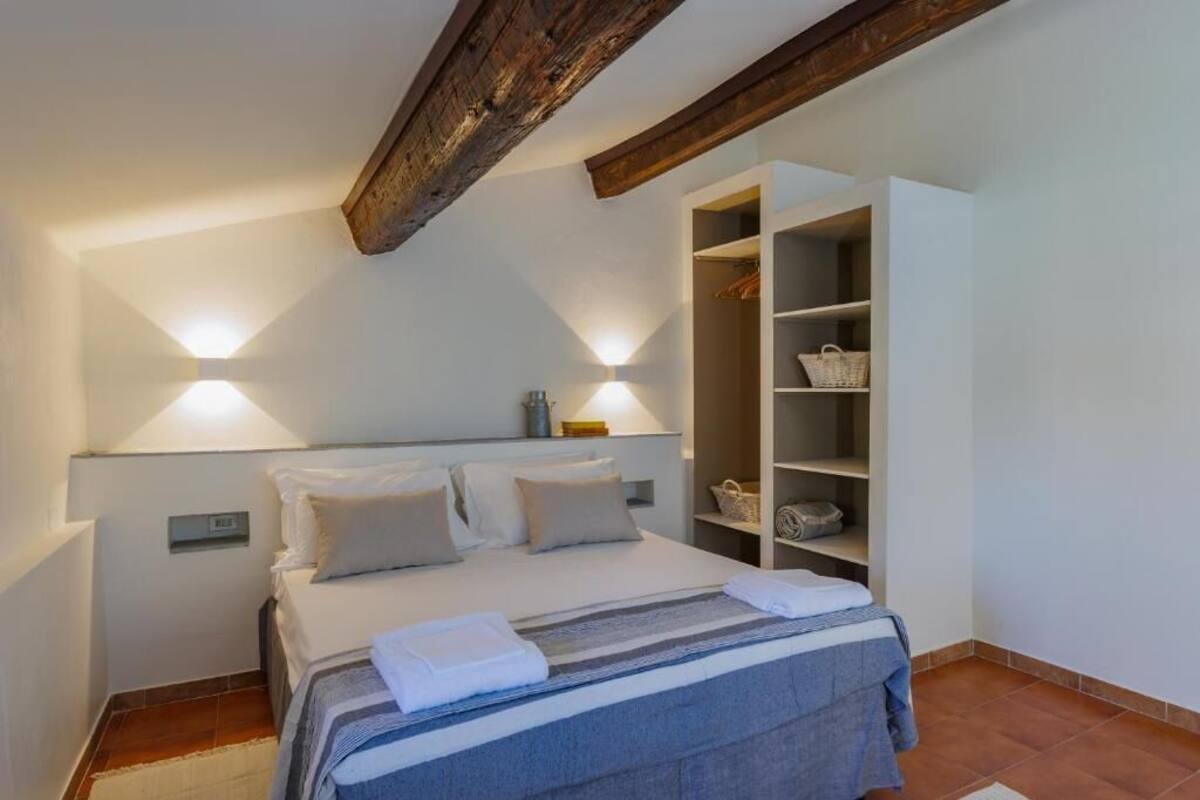 Une chambre à coucher comprenant un lit, des lampes de chevet, une armoire et une table de chevet.