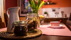 Une table de cuisine avec une carafe, un bocal de biscuits et un vase de tulipes.