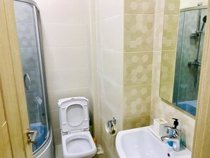 A bathroom with a toilet, a sink, and a shower. - Apartment on Berbuki str. (Tbilisi)