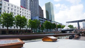 A modern hotel with a white facade and a rooftop terrace with a view of the city skyline. - Boat apartment Rotterdam Fokkelina (Rotterdam)