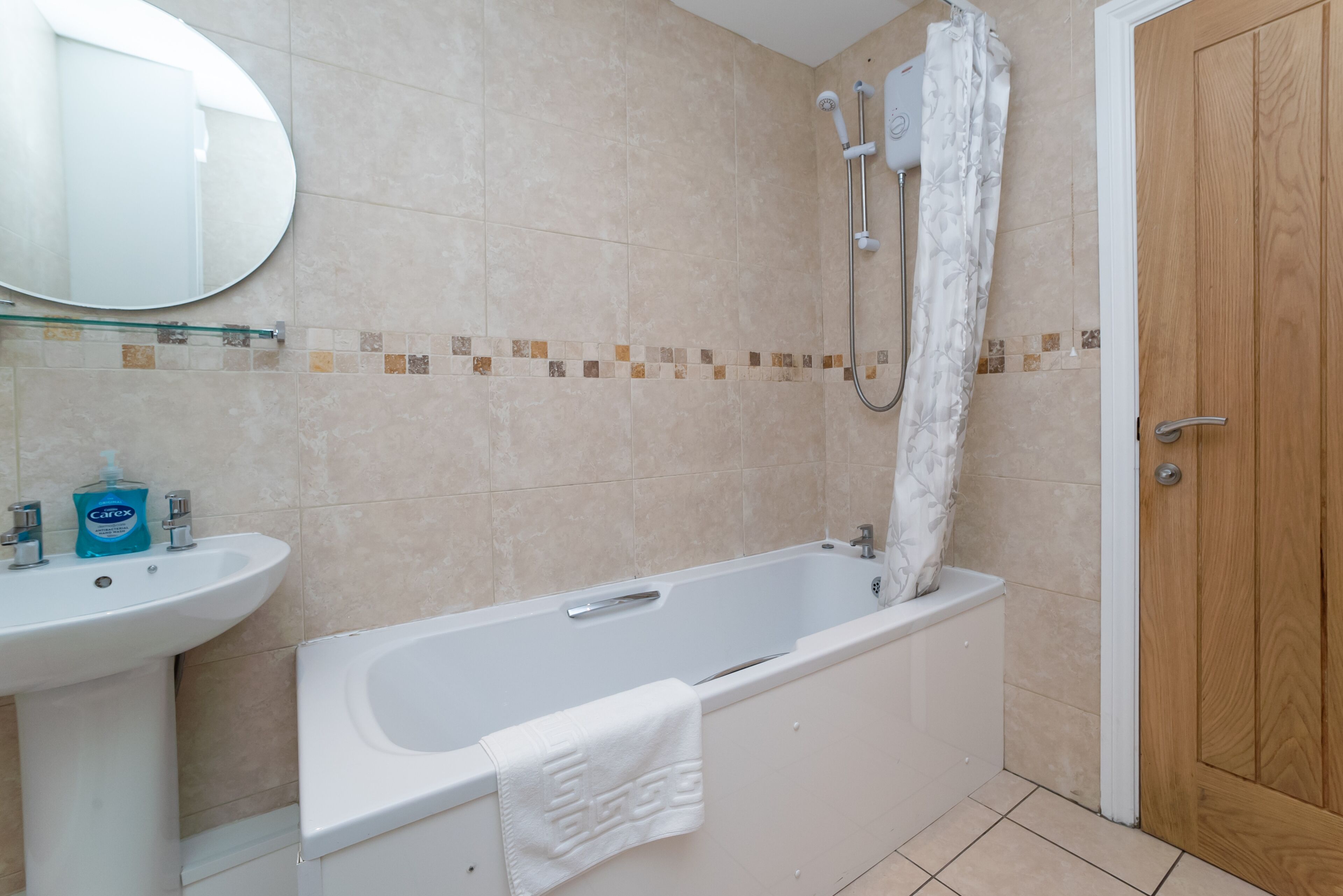 A bathroom with a bathtub, a sink, and a shower.