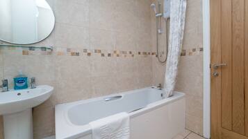 A bathroom with a bathtub, a sink, and a shower.