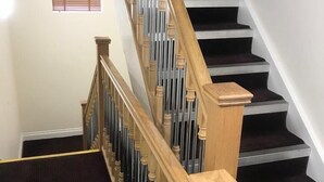 A staircase with wooden handrails and black carpeted steps. - The New Mill Apartments (Newcastle-upon-Tyne)