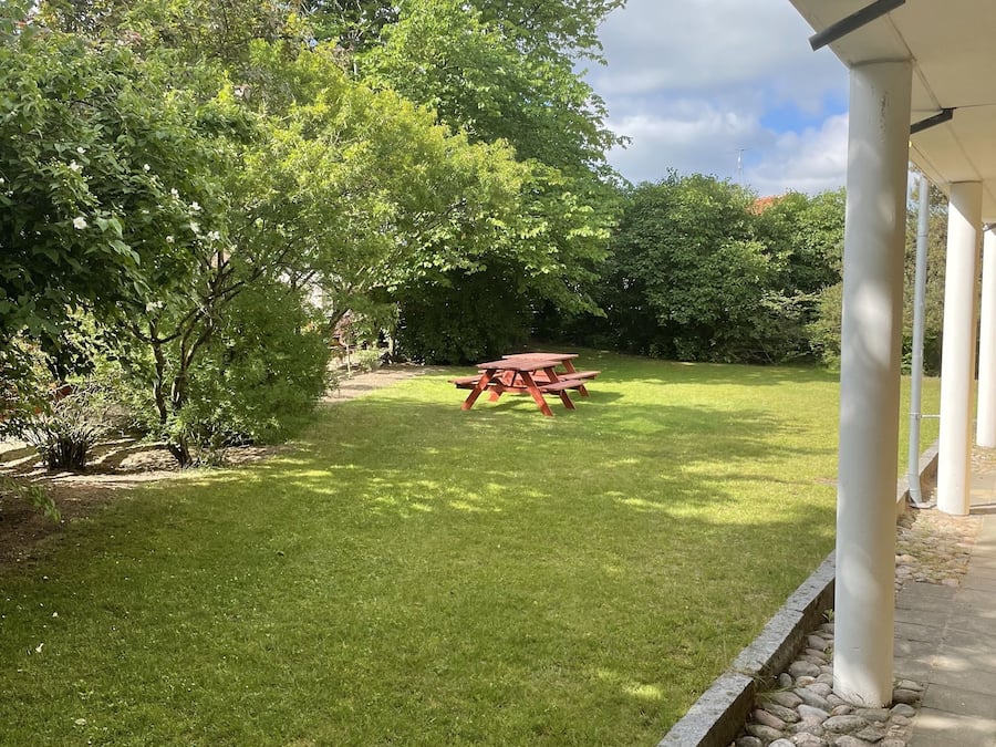 A well-maintained lawn with a picnic table and a stone border.