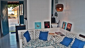Ein Wohnzimmer mit einer Couch, Kissen und gerahmten Bildern an der Wand.