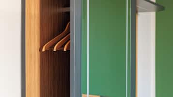 Un armario de madera con espejo y pared verde.