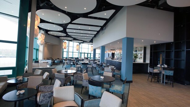 A spacious hotel lobby with multiple seating areas, large windows, and a modern ceiling design. - Brennan Court Guest Accommodation (Limerick)