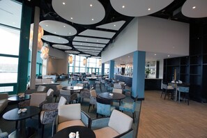 A spacious hotel lobby with multiple seating areas, large windows, and a modern ceiling design. - Brennan Court Guest Accommodation (Limerick)