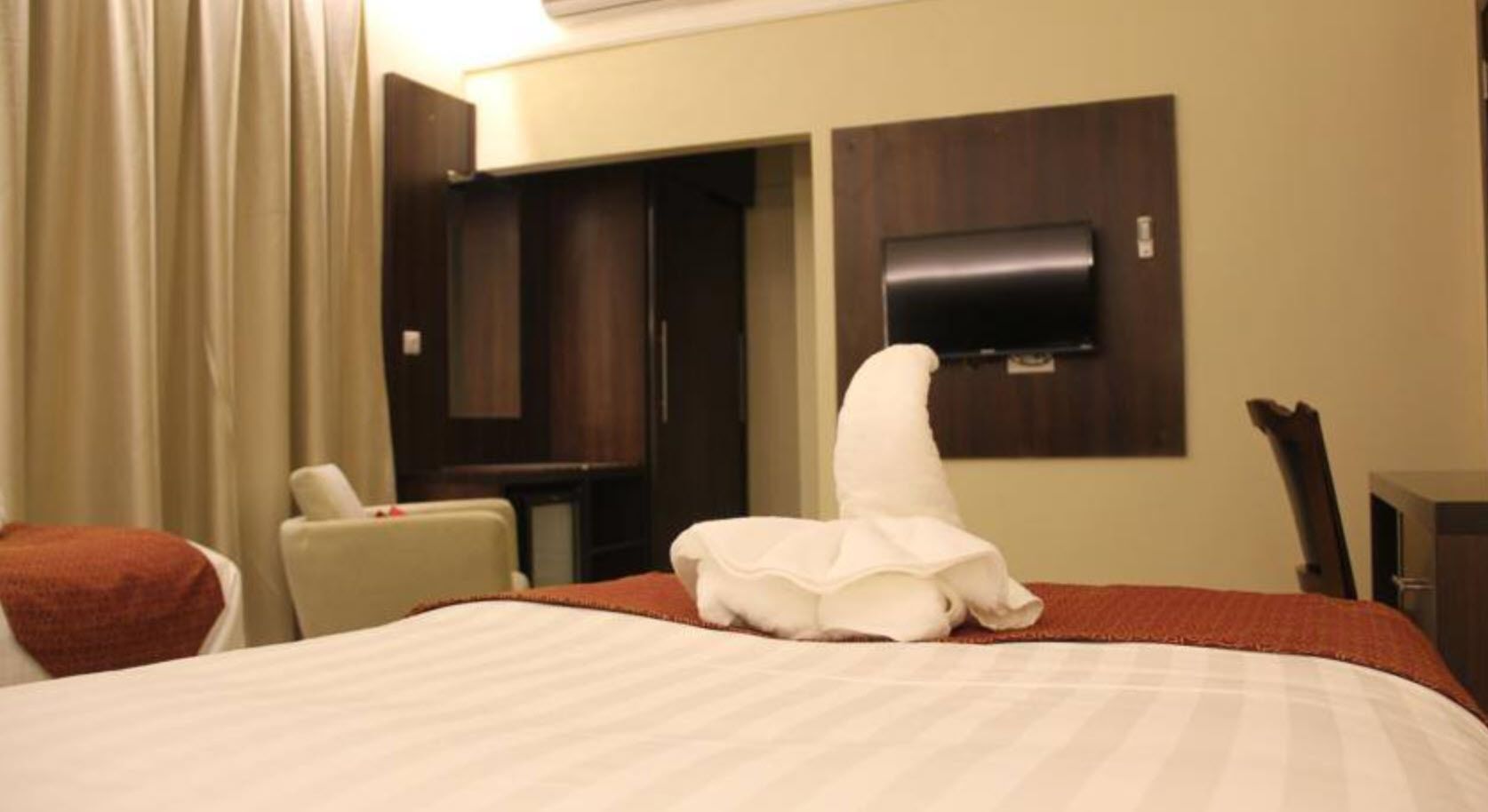 ميني بار وخزنة داخل الغرفة ومكتب وستائر تعتيم