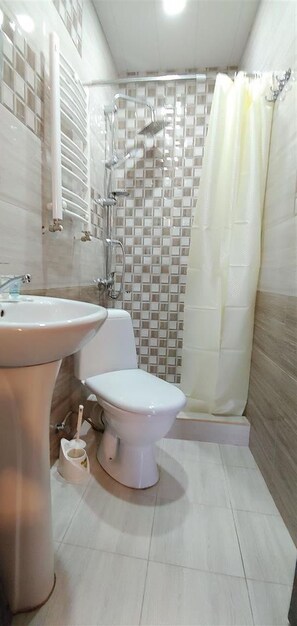 A bathroom with a sink, toilet, and shower area. - Apartment on Marjanishvili Str. (Tbilisi)