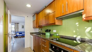Une cuisine moderne avec des meubles en bois, un pare-feu vert et un four encastré.
