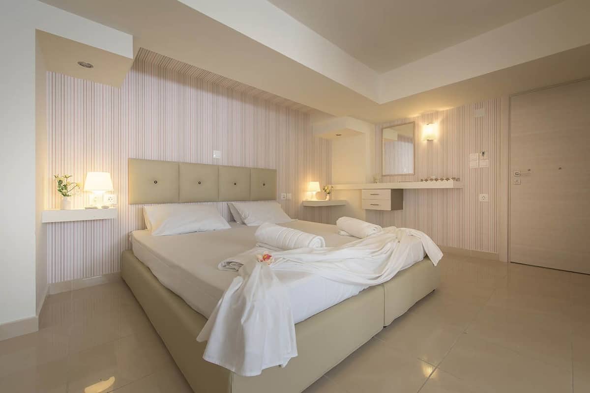Une chambre moderne avec un grand lit, des tables de chevet, un miroir et une armoire.