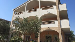 Un immeuble à plusieurs étages doté de balcons et de fenêtres en arc de cercle.