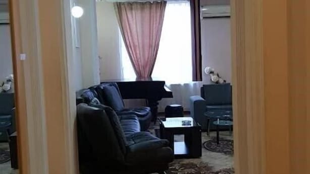 A living room with a sofa, coffee table, and a dining area with chairs. - Apartament on Shartava str. (Tbilisi)