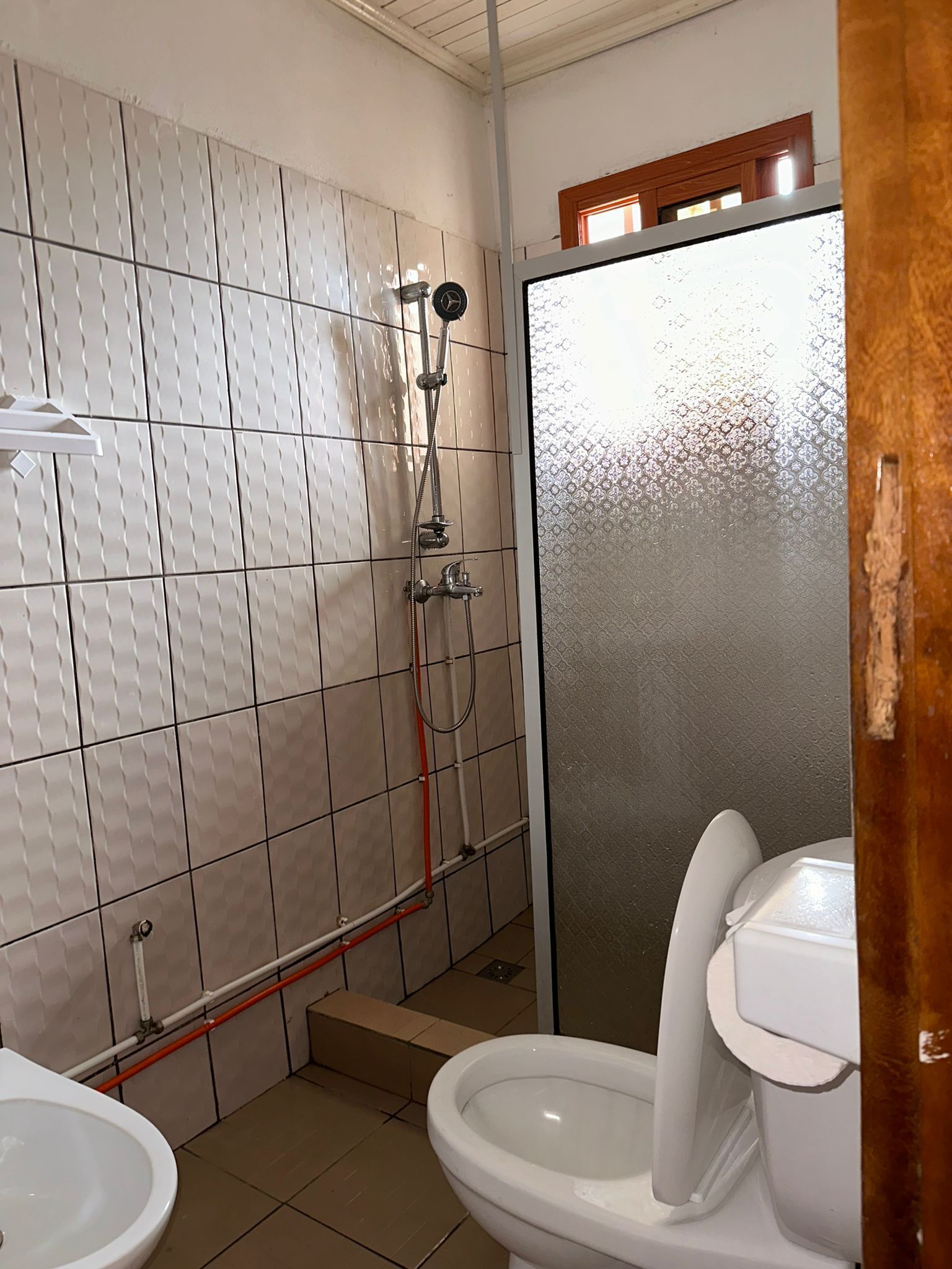 A bathroom with a shower, toilet, and sink.